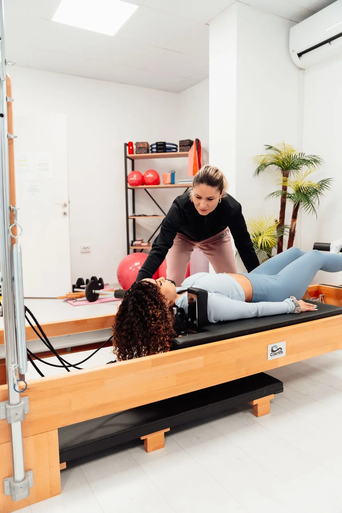 Instructor guiding a client on a reformer
