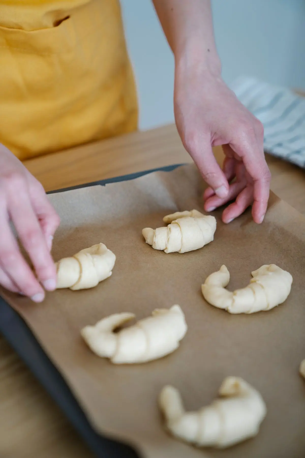 A baker shaping croissant dough